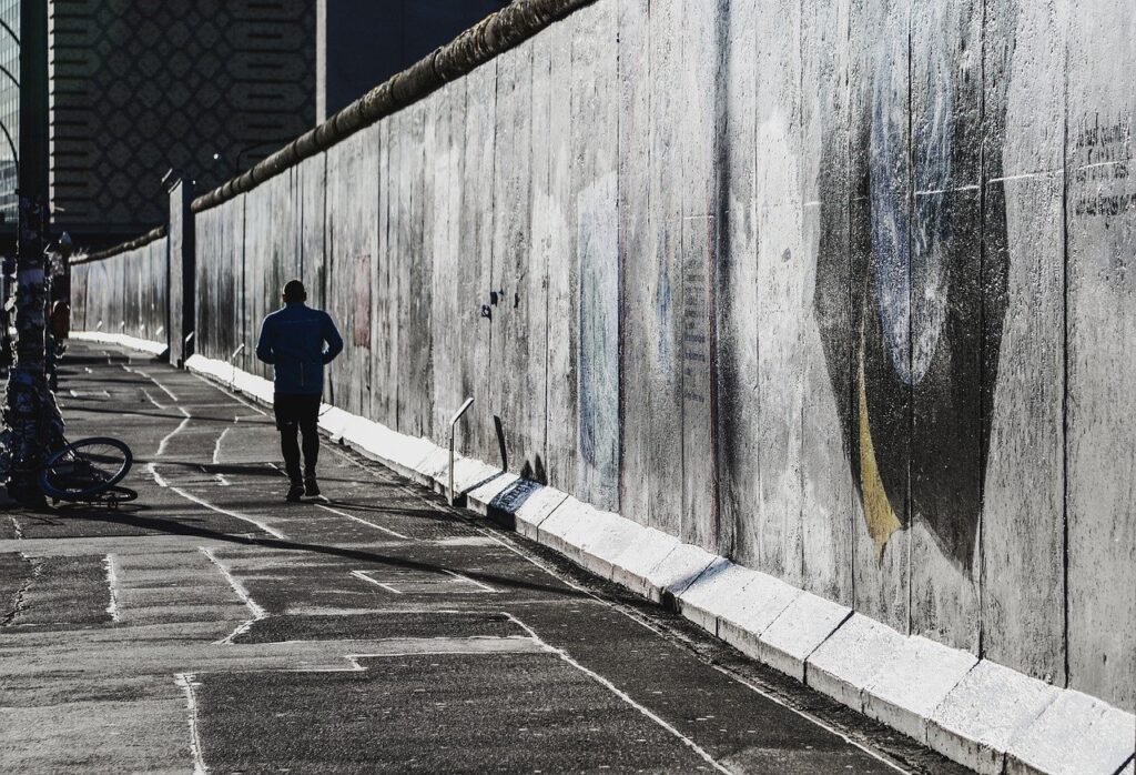 Berliner Mauer. Betonungetüm mit Jogger.