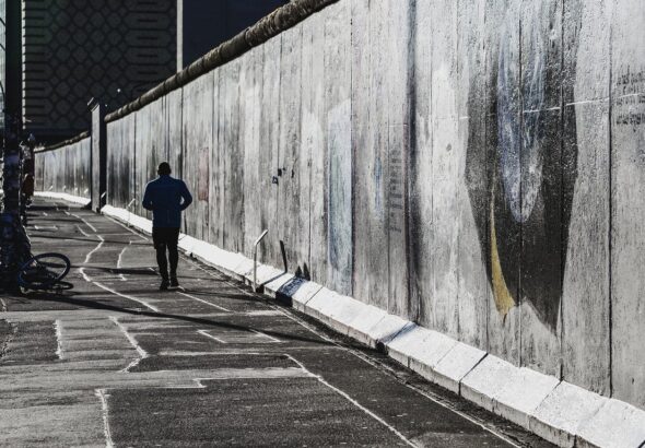 Berliner Mauer. Betonungetüm mit Jogger.