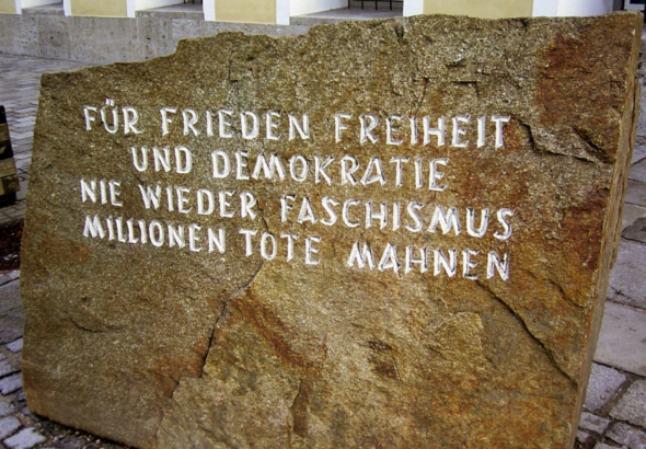 Mahnstein vor dem Geburtshaus Adolf Hitlers. "Für Frieden, Freiheit und Demokratie, nie wieder Faschismus, Millionen Tote mahnen"